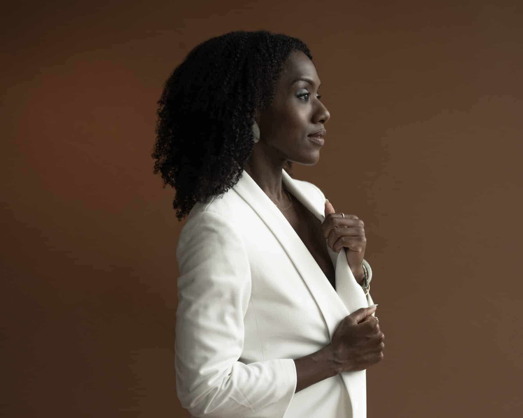 Alicia Waller stands in profile in a white blazer