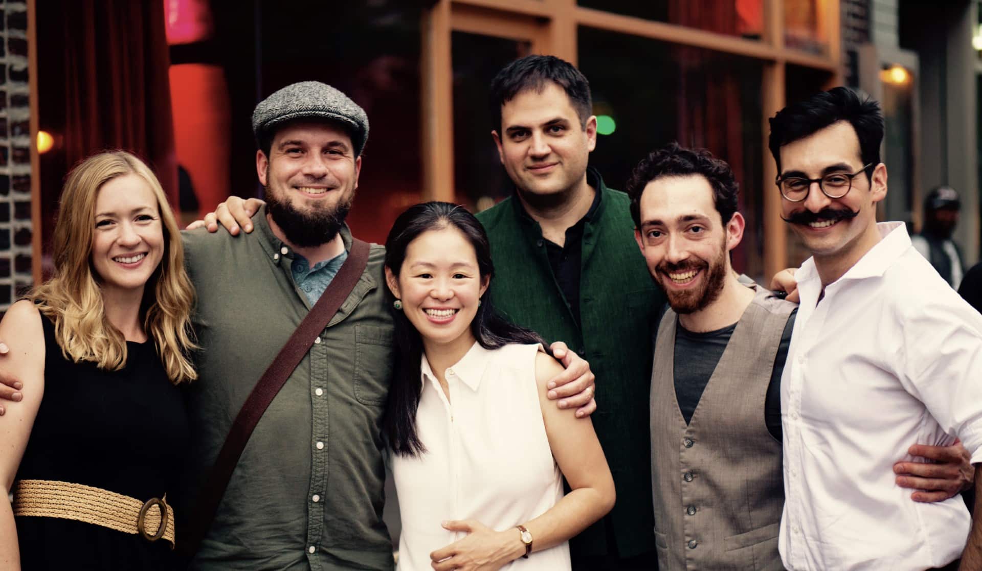 A cheerful gathering of individuals standing close together, smiling for a group photo.